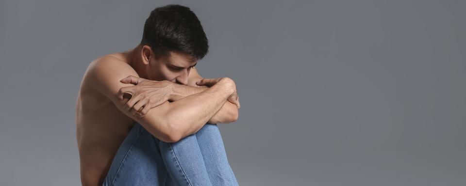 Un jeune homme anorexique regarde avec anxiété des fruits et légumes. [Depositphotos - Serezniy]