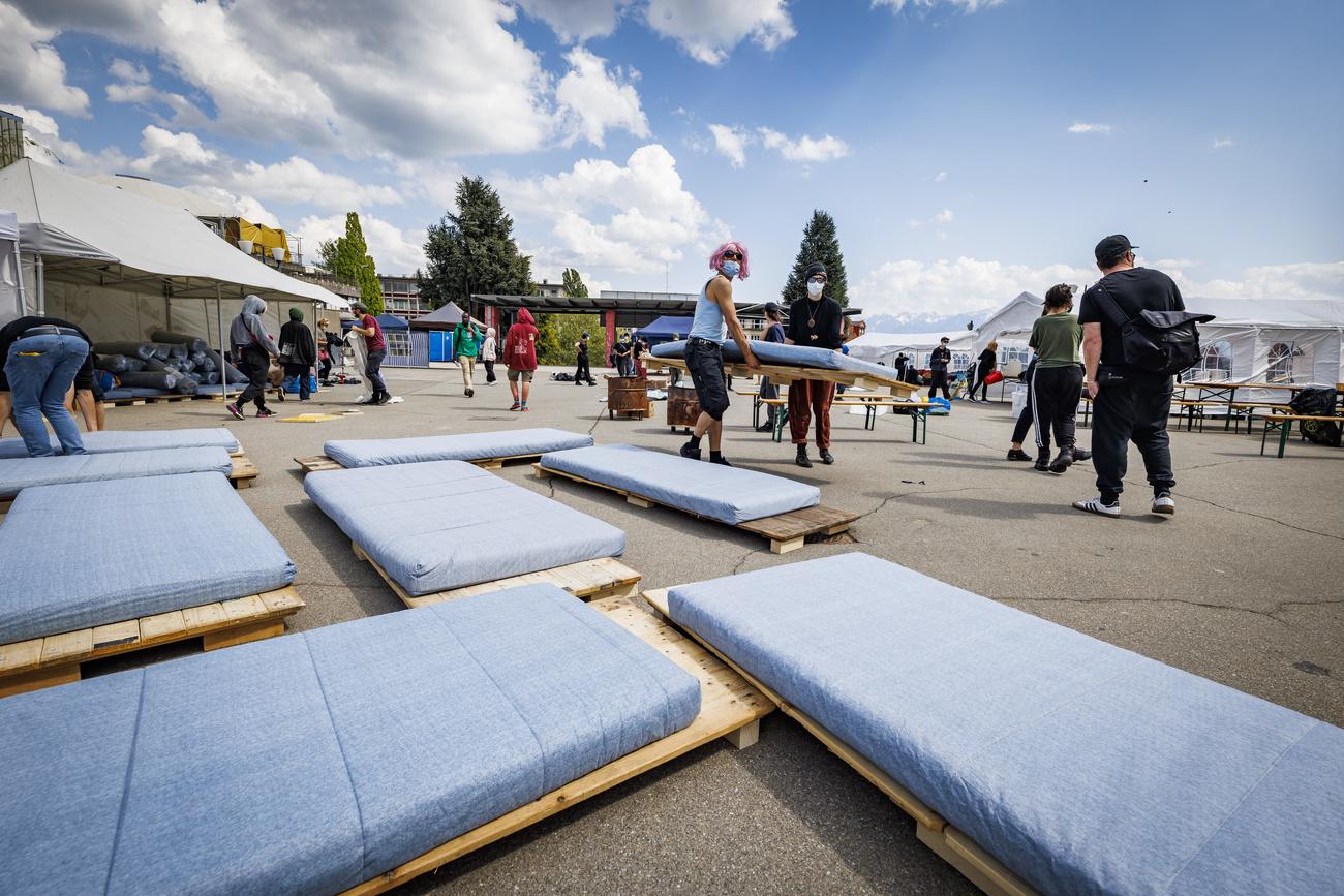 Des activistes du collectif "43m2" installent des lits dans un campement destiné à accueillir des sans-abris dans les jardins du Palais de Beaulieu, le samedi 30 avril 2022 à Lausanne. [KEYSTONE - VALENTIN FLAURAUD]