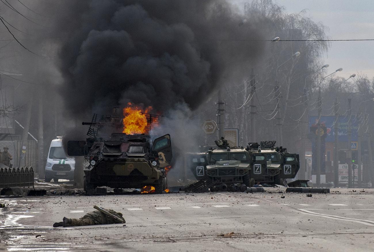 Un véhicule de l'armée russe en feu, le 27 février 2022 à Kharkiv. [KEYSTONE - MARIENKO ANDREW]