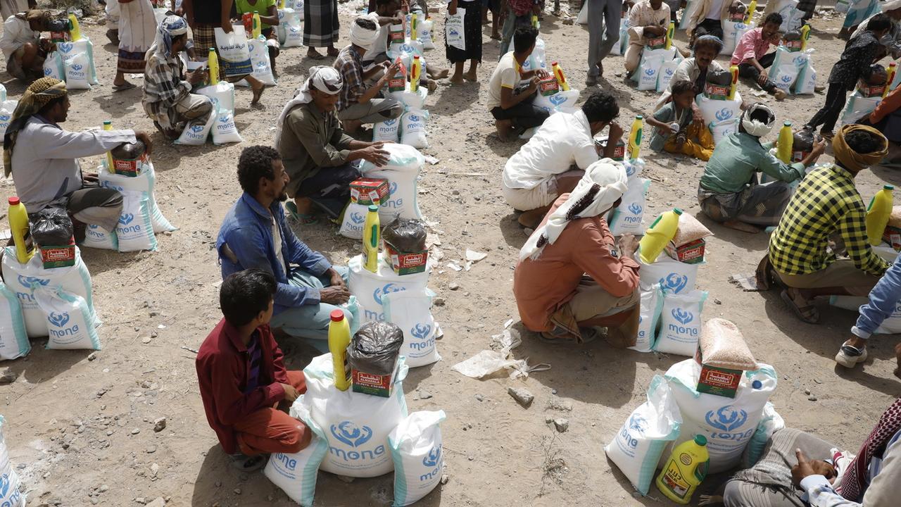 Des personnes reçoivent une aide alimentaire dans la ville d'al-Jarahi, dans la province portuaire de Hodeidah, au Yémen, le 10 février 2022. [Keystone - EPA/YAHYA ARHAB]