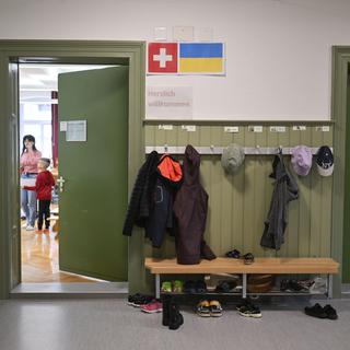 Impressions des drapeaux suisse et ukrainien devant une salle de classe où sont scolarisés des enfants ukrainiens réfugiés, à l'école Landhaus à Herisau. [KEYSTONE - Gian Ehrenzeller]