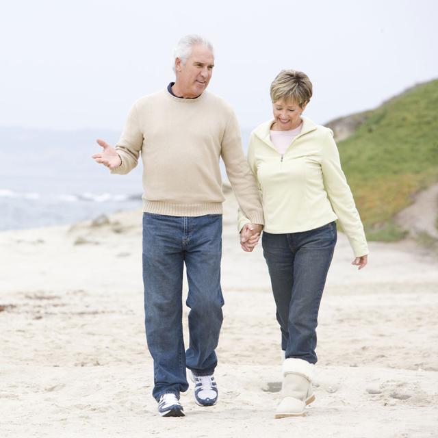 Un couple de senior se promène sur la plage. [Depositphotos - monkeybusiness]