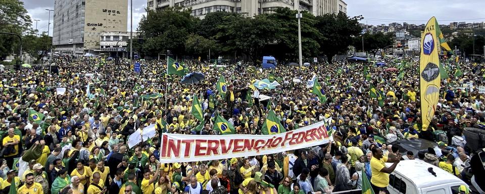 Des partisans du président brésilien sortant Jair Bolsonaro brandissent une bannière demandant une "Intervention fédérale" lors d'une manifestation contre les résultats des élections devant le commandement militaire de l'Est à Rio de Janeiro le 2 novembre 2022. [Keystone - EPA/ANTONIO LACERDA]