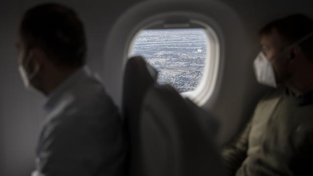 Des passagers portant un masque dans un avion. [Keystone - Christian Beutler]