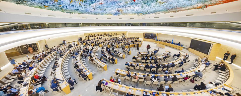 Des délégués assistent à la journée d'ouverture de la 50e session du Conseil des droits de l'homme, au siège européen des Nations unies à Genève, en Suisse, lundi 13 juin 2022. [KEYSTONE - Valentin Flauraud]