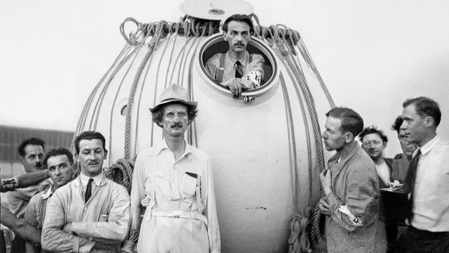 Auguste Piccard portant un chapeau avec Max Cosyns dans la nacelle du ballon stratosphérique. [Keystone]