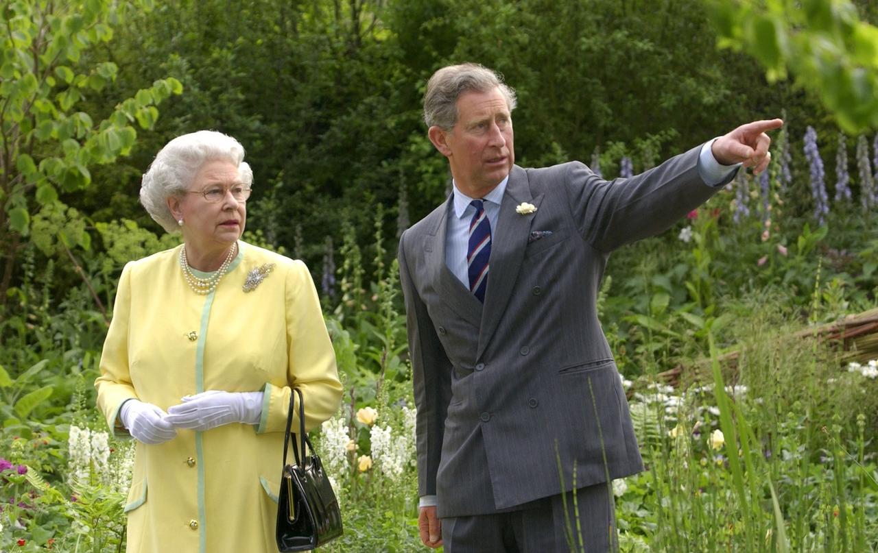 La reine Elizabeth II et le prince de Galles visient le "jardin de guérison" ("Healing Garden") en 2002, conçu par le prince en collaboration avec la designer Jinny Blom. [Keystone - EPA PHOTO WPA POOL / FIONA HANSON / FJH fob]