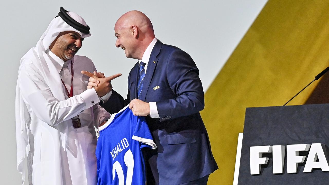 Le président de la FIFA Gianni Infantino remet un maillot au Premier ministre du Qatar. [Keystone - EPA/Noushad Thekkayil]