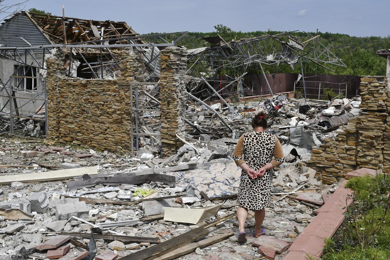 Une femme devant les décombres d'une maison à Sloviansk, en Ukraine. [Keystone - AP Photo/Andriy Andriyenko]