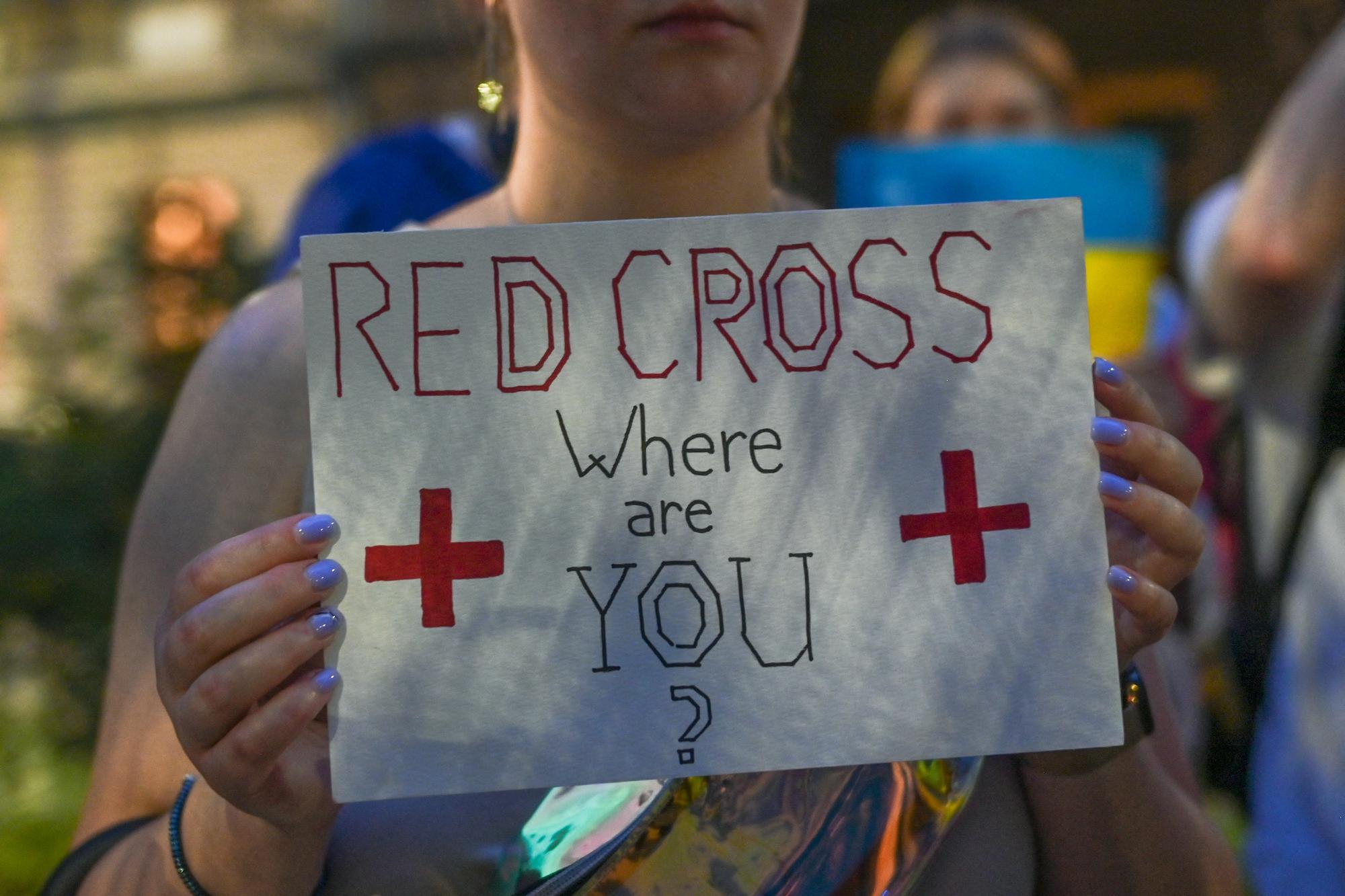 Une affiche "Croix-Rouge, où es-tu?" lors d'une manifestation contre la guerre en Ukraine à Cracovie, en Pologne, en août 2022. [AFP - Artur Widak/NurPhoto]