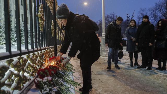 Des personnes se recueillent devant l'ambassade du Kazakhstan à Moscou. [Keystone - EPA/Maxim Shipenkov]