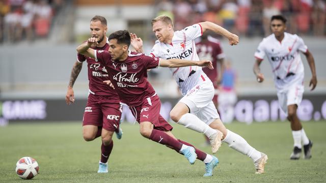 Le défenseur genevois Steve Rouiller, à gauche, et le milieu de terrain genevois Boris Cespedes, au centre, se disputent le ballon avec l'attaquant valaisan Gaetan Karlen, à droite, lors du match de Super League entre le FC Sion et le Geneve Servette FC, le dimanche 22 mai 2022 au Stade de Tourbillon à Sion. [KEYSTONE - Cyril Zingaro]