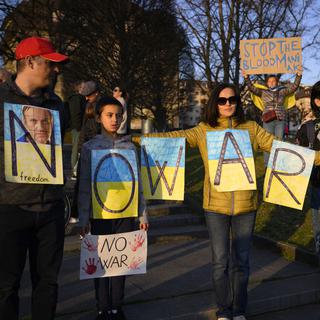 Des manifestants portent des pancartes portant l'inscription "Non à la guerre" alors qu'ils participent à une manifestation contre l'invasion de l'Ukraine par la Russie à Lausanne. [Keystone - Laurent Gillieron]