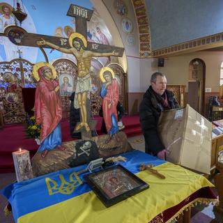 Un bénévole porte une boîte de dons destinée à l'Ukraine à l'église catholique ukrainienne St. Michael à Montréal, jeudi 3 mars 2022. [The Canadian Press via AP/KEYSTONE - Paul Chiasson]