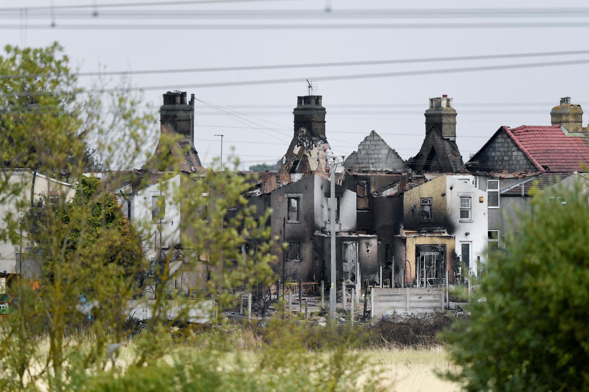 Plusieurs propriétés du village de Wennington, dans l'Essex, en Angleterre, ont été détruites par les flammes. [Reuters - Tony O'Brien]