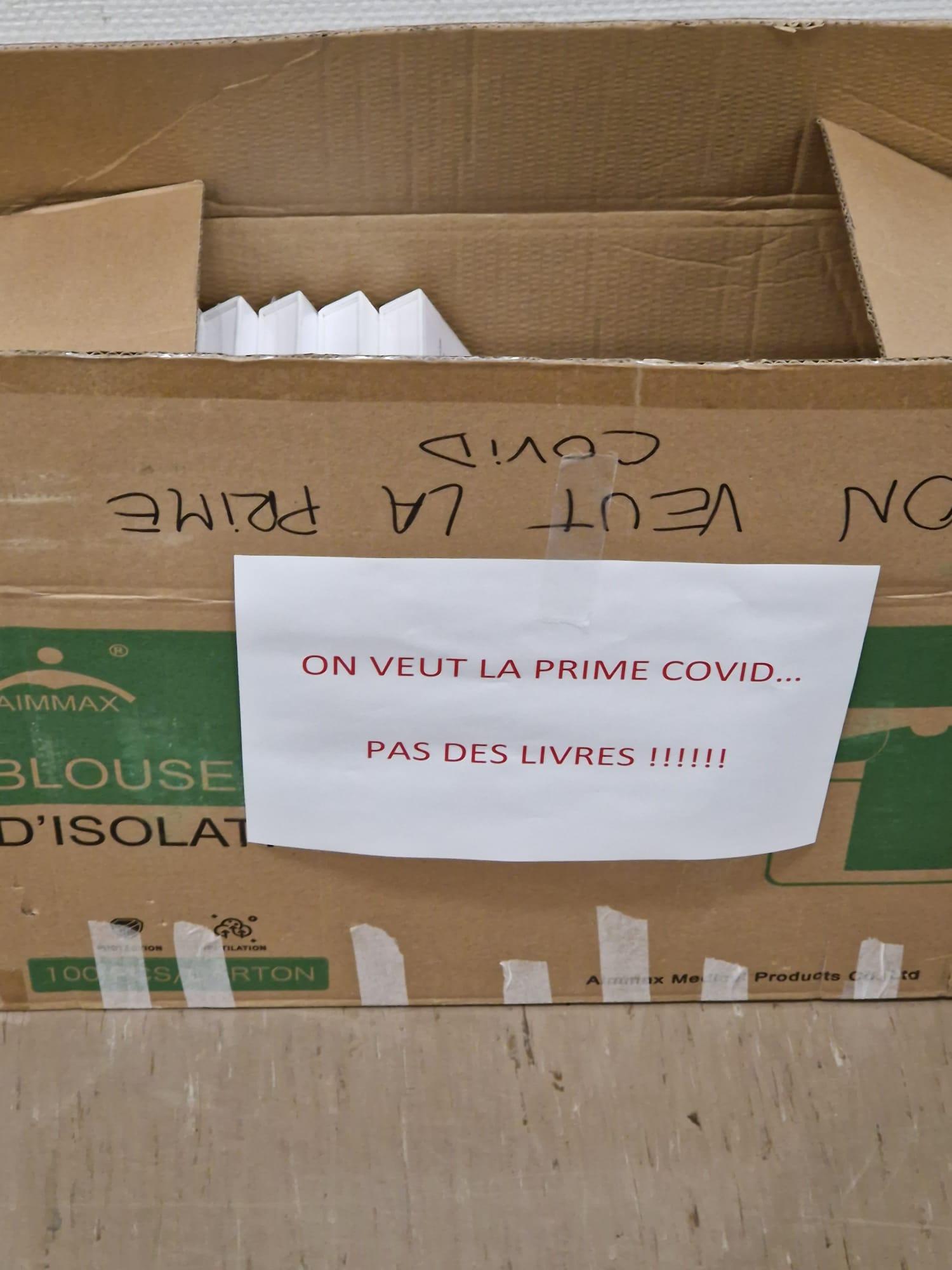 Dans l'un des services du CHUV, un carton sur lequel il est inscrit "on veut la prime Covid... Pas de livres!" a été installé. [DR]