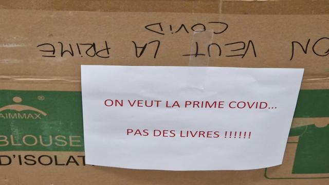 Dans l'un des services du CHUV, un carton sur lequel il est inscrit "on veut la prime Covid... Pas de livres!" a été installé. [DR]