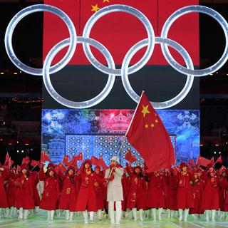 Gao Tingyu et Zhao Dan, de Chine, portent leur drapeau national dans le stade lors de la cérémonie d'ouverture des Jeux olympiques d'hiver de 2022, vendredi 4 février 2022, à Pékin. [AP Photo/KEYSTONE - Jae C. Hong]