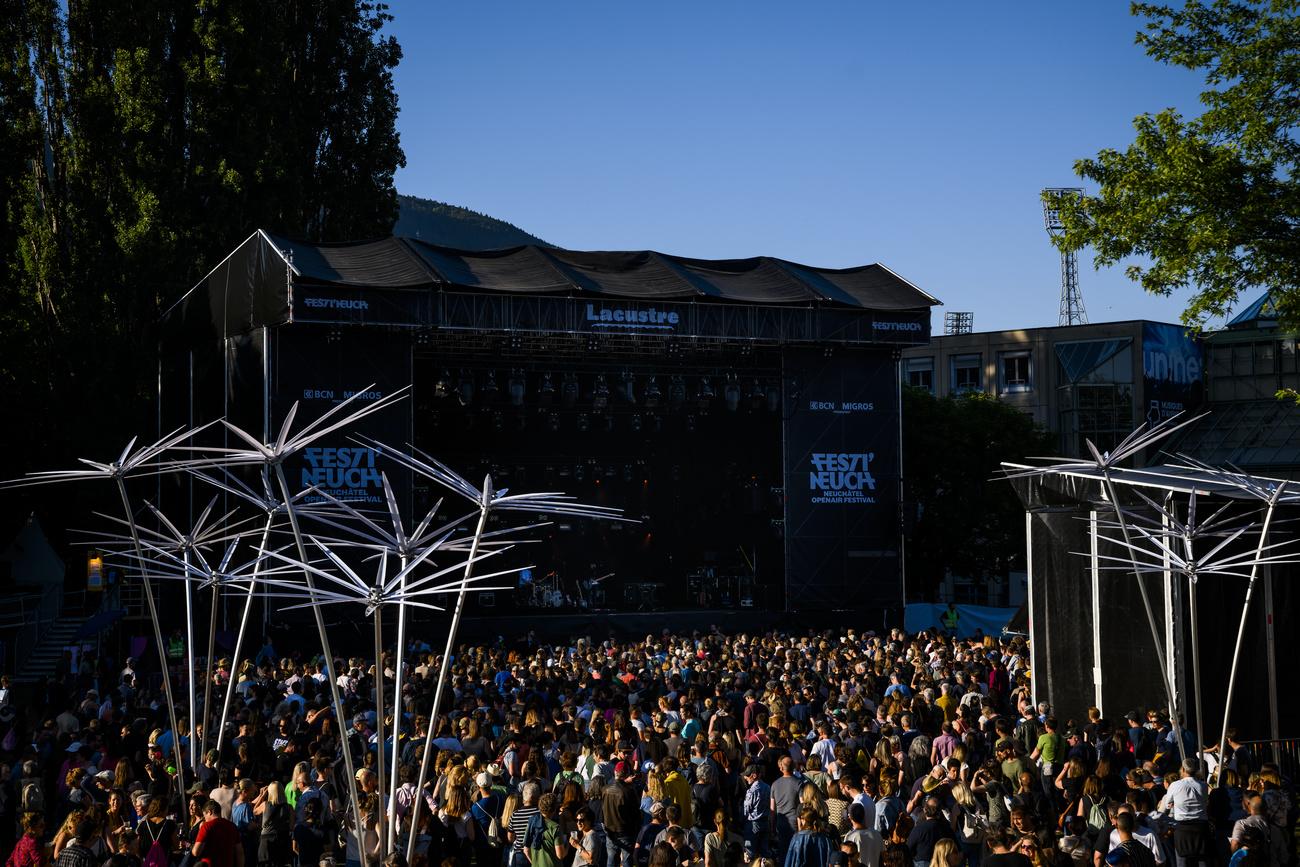 Des personnes assistent au concert de la chanteuse Emilie Zoé devant la scène Lacustre lors du festival open air Festi'Neuch, le vendredi 10 juin 2022 à Neuchâtel. [KEYSTONE - Jean-Christophe Bott]