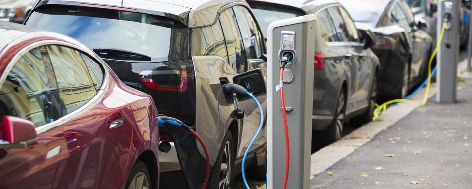 De nombreuses voitures électriques en chargement dans la rue. [Depositphotos - Scharfsinn]