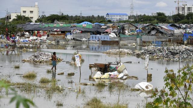 Un homme marche dans un quartier inondé après de fortes pluies à Bangalore, en Inde, le 7 septembre 2022. [AFP - Manjunath Kiran]