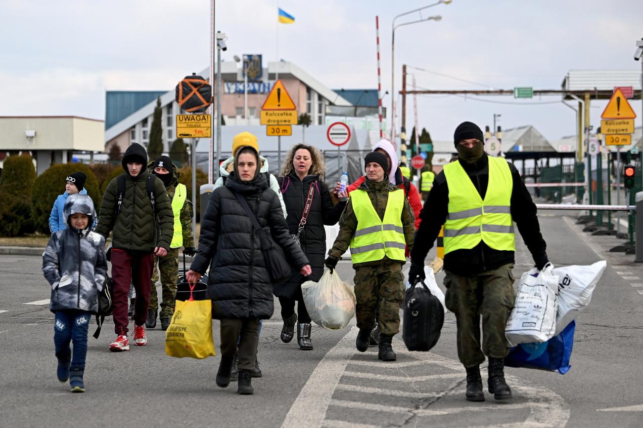 Des réfugiés ukrainiens sont pris en charge à la frontière avec la Pologne, à Korczowa, le 10 mars 2022. [Keystone - EPA/DAREK DELMANOWICZ]