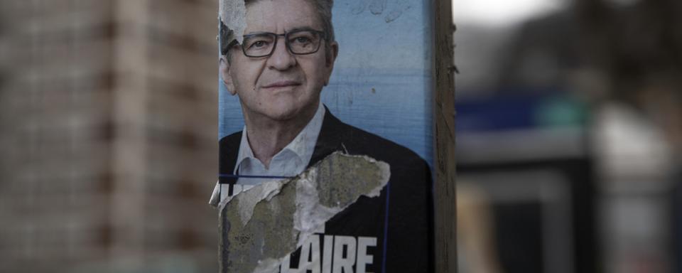 Une affiche déchirée de Jean-Luc Mélenchon. [Keystone/AP Photo - Adrienne Surprenant]