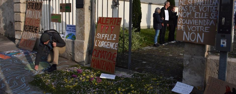 Des manifestants pour le climat accueillent les parlementaires jurassiens à Delémont. [RTS - Gaël Klein]