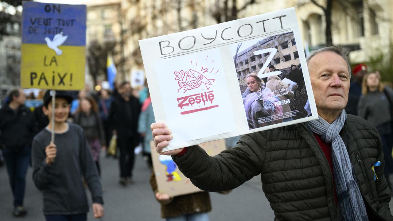Un appel au boycott de Nestlé lors d'une manifestation contre la guerre en Ukraine à Lausanne, 22.03.2022. [Keystone - Laurent Gilliéron]