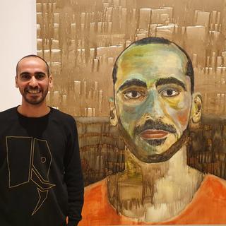 Mostafa Azimitabar devant son autoportrait peint à l'aide d'une brosse à dent. [Art Gallery NSW]