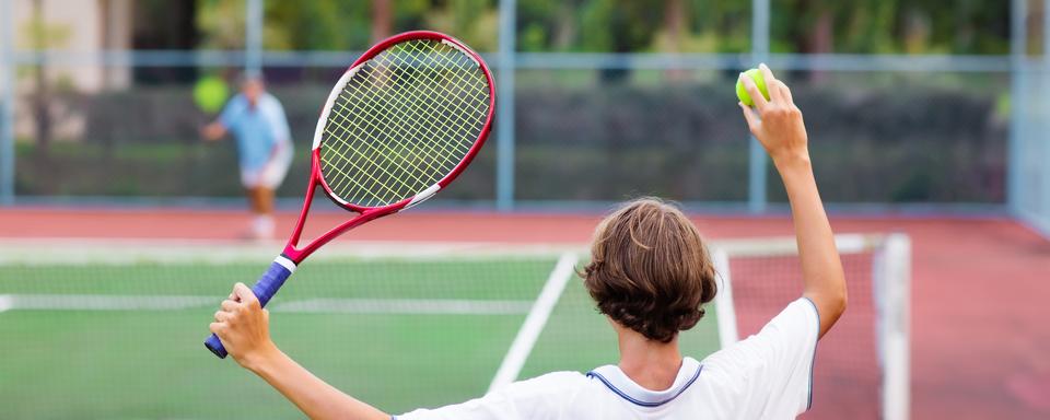 Garçon jouant au tennis de dos. [Depositphotos - FamVeldman]