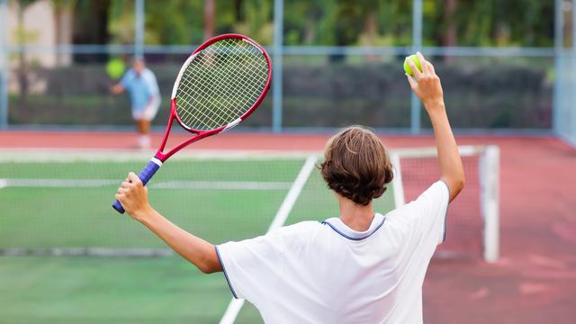 Garçon jouant au tennis de dos. [Depositphotos - FamVeldman]