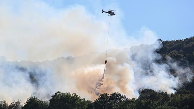 Jeudi 11 août: un hélicoptère déverse de l'eau sur un incendie à Cernon, dans le Jura français. [afp - Jean-Philippe Ksiazek]