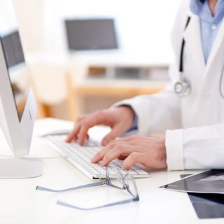 Un médecin entre des données dans le dossier électronique d'un patient. [Depositphotos - perig76]