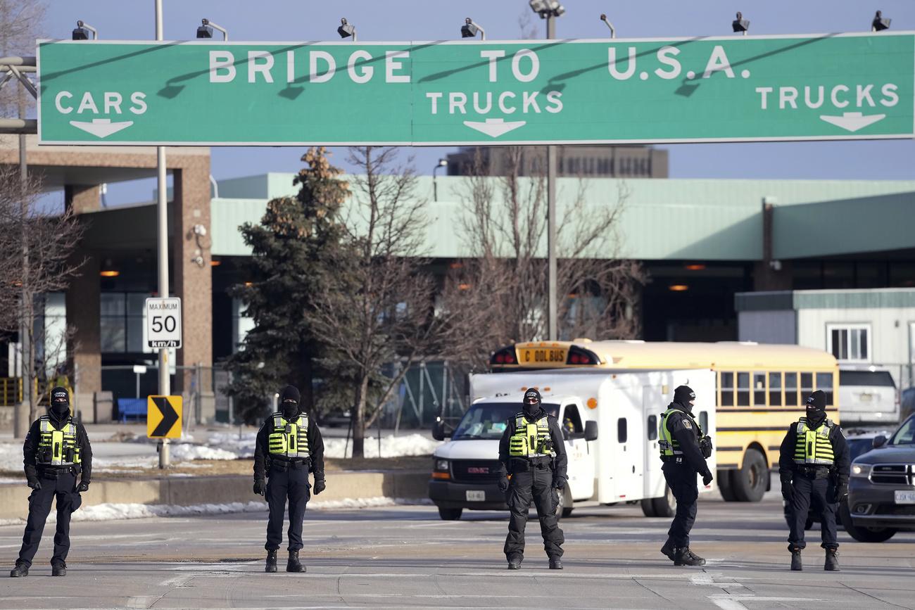 La police a pris position en nombre aux abords du pont Ambassador, qui relie Windsor en Ontario à la ville américaine de Detroit. [Keystone - Nathan Denette/The Canadian Press via AP]