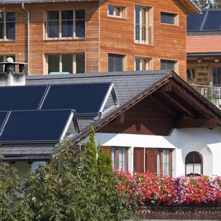 Panneaux solaires sur le toit d'une maison à Flerden, dans les Grisons. [Keystone - Gaëtan Bally]