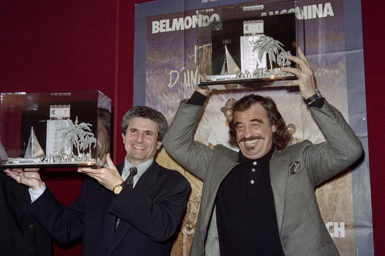 Le réalisateur Claude Lelouch (à gauche) et l'acteur Jean_Paul Belmondo fêtent le record de 100'000 vidéos vendues de leur film "Itinéraire d'un enfant gâté". [AFP - Pascal George]