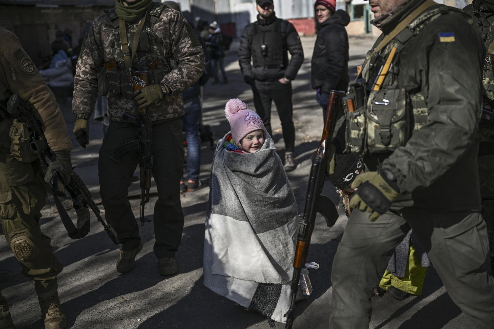 Un enfant attend d'être évacué de la ville d'Irpin, au nord de Kiev, alors que les forces russes ont atteint le 10 mars 2022 la limite nord-est de la capitale. [AFP - Aris Messinis]