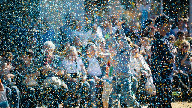 Des enfants lancent des confettis à la Fête des Vendanges à Neuchâtel. [Keystone - Stefan Meyer]