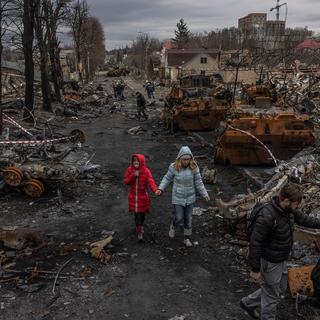 Jeudi 7 avril: des personnes déambulent au milieu du champs de ruines qu'est devenue Boutcha, petite ville près de Kiev, théâtre d'exactions par les forces russes qui l'occupaient. [EPA/Keystone - ROMAN PILIPEY]
