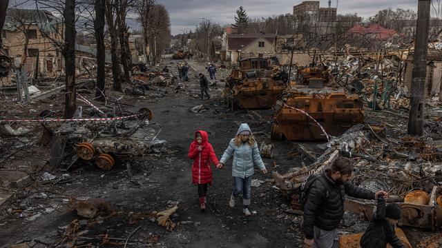 Jeudi 7 avril: des personnes déambulent au milieu du champs de ruines qu'est devenue Boutcha, petite ville près de Kiev, théâtre d'exactions par les forces russes qui l'occupaient. [EPA/Keystone - ROMAN PILIPEY]