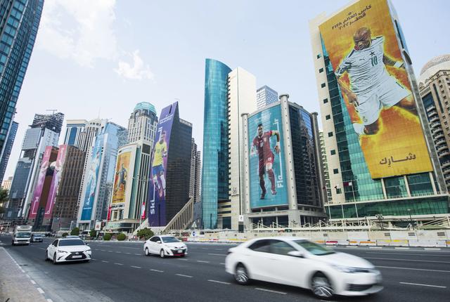 Les tours de Doha se parent d'images de footballeurs, à la veille du coup d'envoi du Mondial au Qatar. [EPA/Keystone - Noushad Thekkayl]