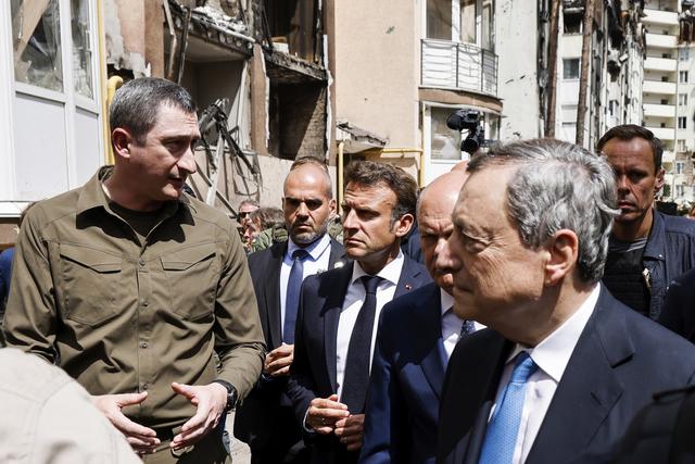 Emmanuel Macron, Olaf Scholz et Mario Draghi en visite dans une banlieue détruite de Kiev. [Keystone - Ludovic Marin, Pool via AP]