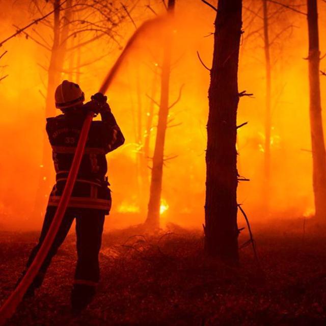 Un pompier luttant contre le feu de forêts en Gironde. [Keystone - EPA/SDIS 33]