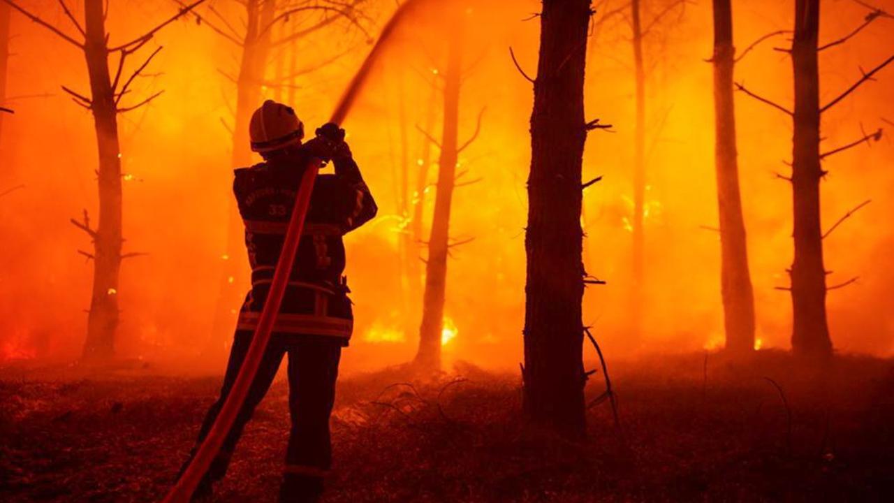 Un pompier luttant contre le feu de forêts en Gironde. [Keystone - EPA/SDIS 33]