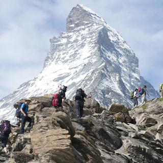 Des randonneurs et randonneuses marchent en direction du Cervin, lors de la cérémonie d'ouverture du Base Camp Matterhorn en 2014. [Keystone - Anthony Anex]