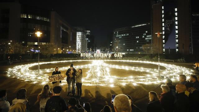 Un réfugié ukrainien participe à une campagne d'Aavaz montrant un signe de paix géant et l'huile Stop Poutine lors d'une manifestation contre l'invasion russe de l'Ukraine à Bruxelles, en Belgique, le 22 mars 2022. [KEYSTONE - Olivier Hoslet]