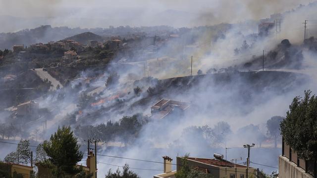 Un feu près des habitations vers Athènes. [Keystone - AP Photo/Lefteris Pitarakis]