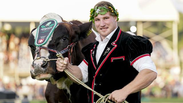 Joel Wicki pose avec le taureau Magnus II, le premier prix de la Fête fédérale 2022. [Freshfocus - Claudio Thoma]