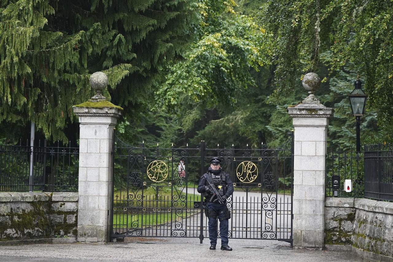 Un policier armé devant les grilles du château de Balmoral. [Keystone - Andrew Milligan/PA via AP]